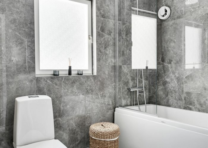handyman plumber las vegas Elegant bathroom interior featuring marble tiles, toilet, and bathtub in modern design.