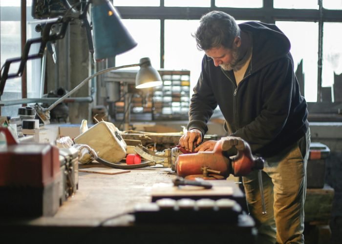 Handyman working with tools Handyman working with tools and metal details in lamplight in workshop